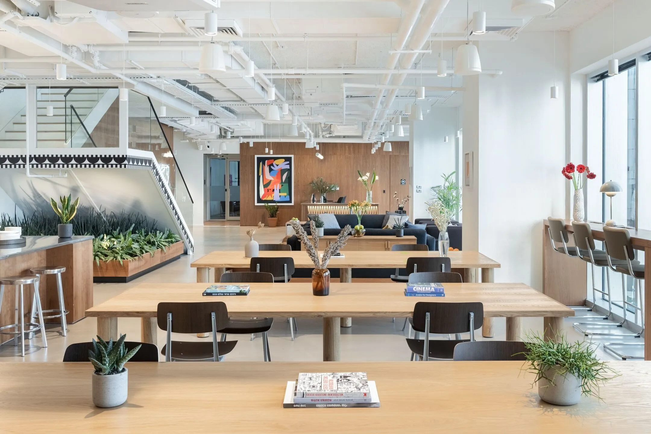 Architectural studio interior with angled daylight across oak tables